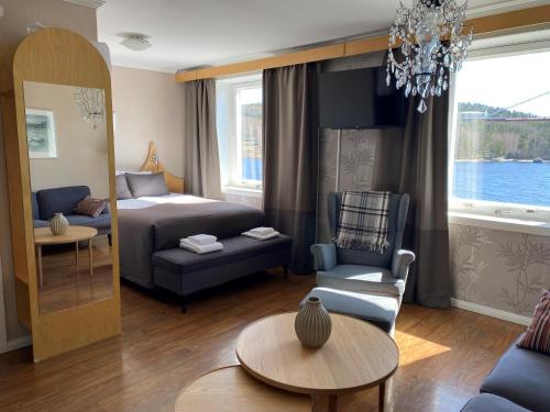 een woonkamer met een bed, een bank en een tafel bij Björkuddens Hotell & Restaurang in Sandöverken