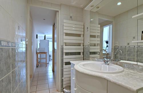 a white bathroom with a sink and a mirror at La Petite Maison Blanzy in Blanzy