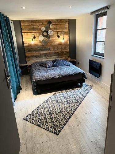 une chambre avec un lit et un mur en bois dans l'établissement Appartement chaleureux avec place de parking, à Turckheim