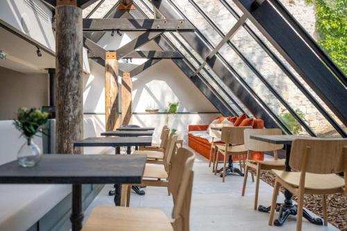 une salle à manger mansardée avec des tables et des chaises dans l'établissement Hôtel Saint Nicolas, à La Rochelle
