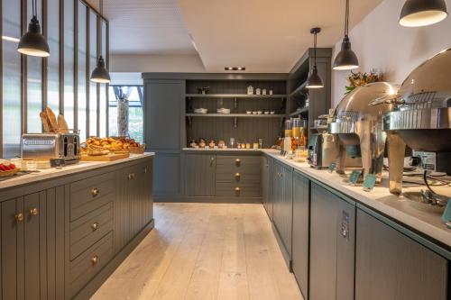 a kitchen with blue cabinets and a counter with food at Le Saint-Nicolas H&ocirc;tel in La Rochelle
