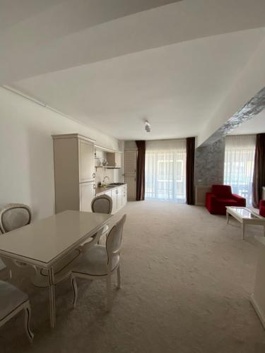 - un salon avec une table et un canapé rouge dans l'établissement Apartament Miramare Mamaia Nord, à Mamaia Nord – Năvodari