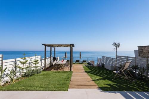 a boardwalk leading to the beach with a pavilion at Deux Paradis, a BeachFront Retreat, By ThinkVilla in Rethymno Town