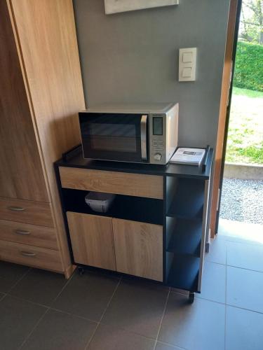 un four micro-ondes installé au-dessus d'un comptoir noir dans l'établissement A La Reid Paisible, à Theux