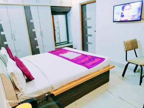 a bedroom with a bed and a chair in it at Homestayinn in Ahmedabad