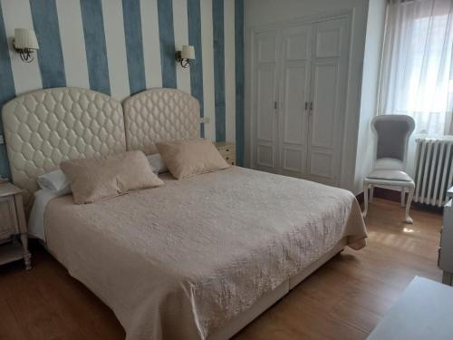 a bedroom with a large bed and a chair at Marina in Ribadesella