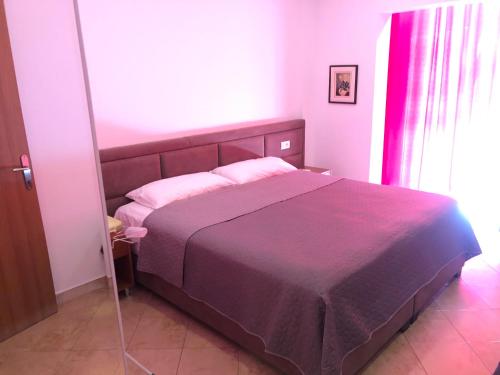 a bedroom with a large bed with a purple blanket at HOTEL Apartments ARDO in Golem