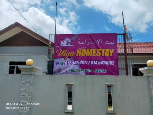 una pancarta púrpura al lado de un edificio en Ulya Homestay 3, en Jertih