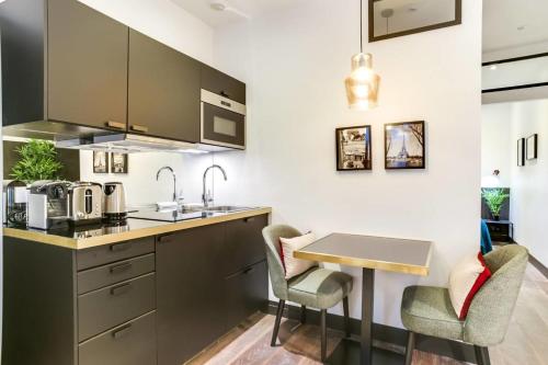 uma cozinha com uma mesa e duas cadeiras em GuestReady - Exquisite Apartment in the Historical 7th District em Paris