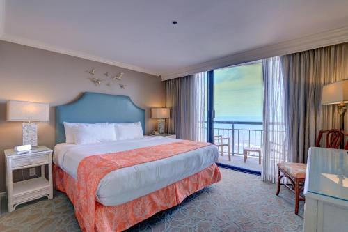 Habitación de hotel con cama y balcón en Gorgeous San Luis Condo Amazing Pool Amenities Ocean Views From 2 Balconies, en Galveston