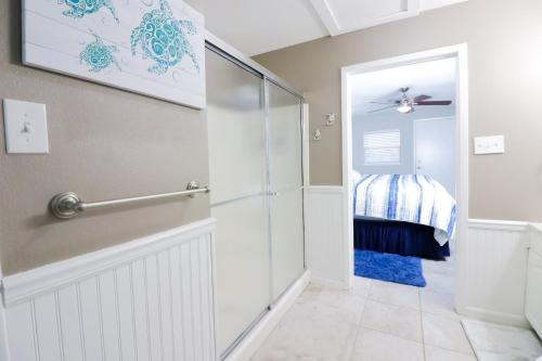 a bathroom with a walk in shower next to a crib at SUNNY DAZE Walk to Beach 2 Decks Pet Friendly Has a Mini Bar in Galveston