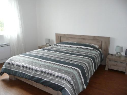 - un lit avec une couverture rayée dans une chambre dans l'établissement Apartment in Lilia near Sandy Kastell Ac'h Beach, à Plouguerneau