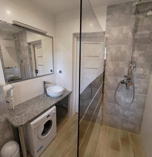 a bathroom with a shower and a washing machine at Dwunastka in Zakopane