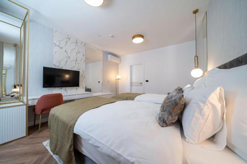 a hotel room with a large bed and a flat screen tv at Hotel Millennium by Aycon in Budva