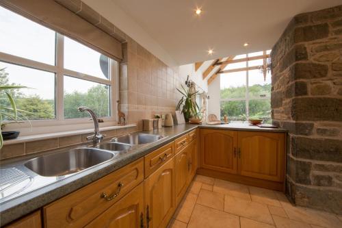 a kitchen with a sink and a stone wall at Errichel House and Cottages in Aberfeldy