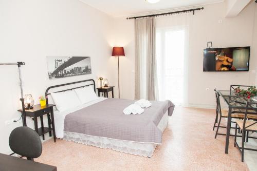 um quarto com uma cama, uma mesa e cadeiras em Ioannis Apartments em Atenas