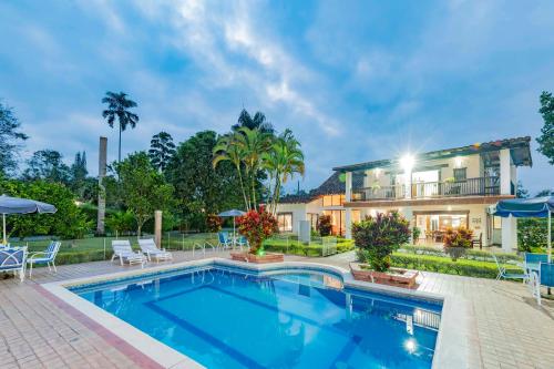 a swimming pool in front of a house at Casa Campestre La Habana in Armenia