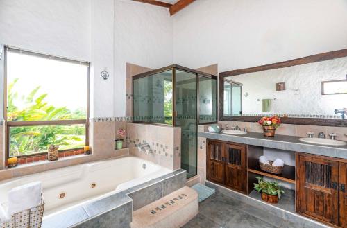 a bathroom with a tub and two sinks and a large window at Casa Campestre La Habana in Armenia