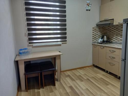 a kitchen with a table and a window in a room at Gold Hotel Quba in Quba