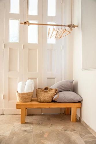 a bench with two baskets and two pillows in a room at Phaos I in Kyparissia