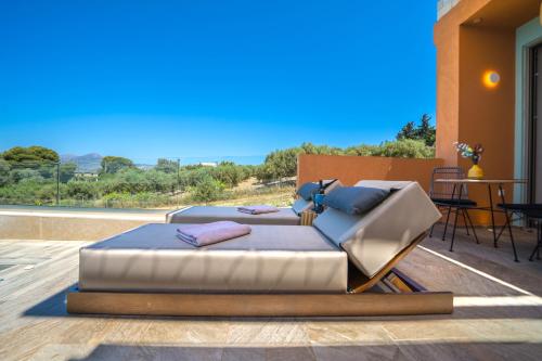 a bed and a couch sitting on a deck at Oleas Suites in Voútai