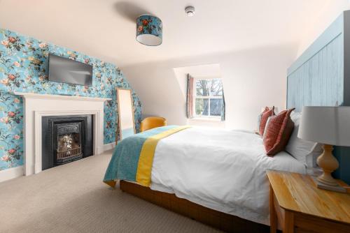 a bedroom with a bed and a fireplace at The Cottage, The Loch Ness Cottage Collection in Inverness