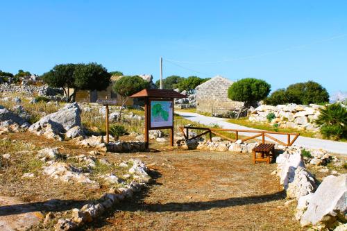 a sign in a field with rocks and a road at Ai piedi di Cofano in Custonaci