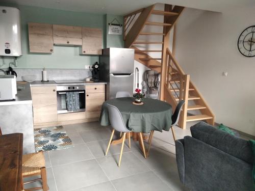 une cuisine et une salle à manger avec une table et un escalier dans l'établissement Agréable Maison proche Etretat, à Criquetot-lʼEsneval