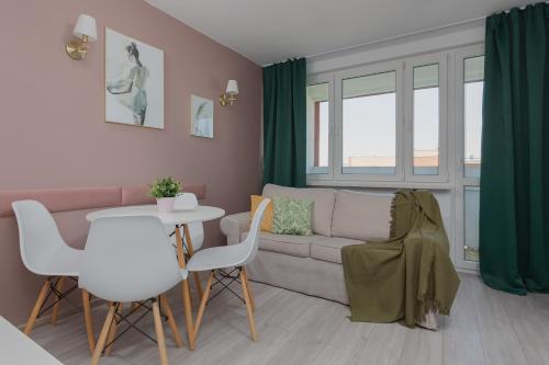 Apartaments Solec 79 by Renters في وارسو: غرفة معيشة مع أريكة وطاولة وكراسي