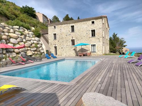 un immeuble avec une piscine devant un immeuble dans l'établissement A Vignarella, à Ventiseri