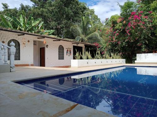 a swimming pool in front of a house at Villa Clara Casa Campestre, Piscina, Naturaleza, Paseo de Río in Melgar