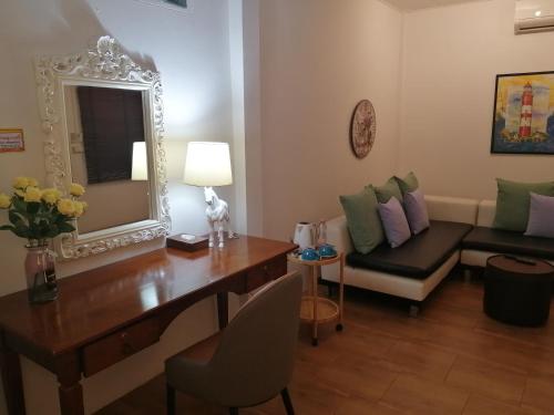 a living room with a desk and a mirror at Rynn Hotel in Trat