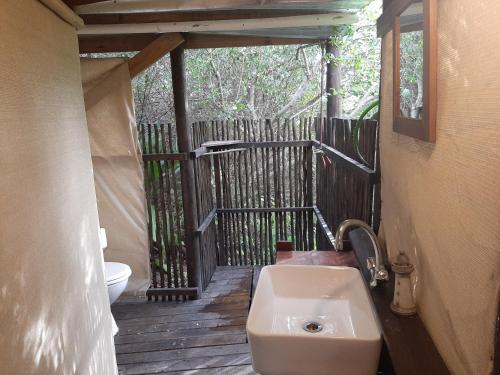 a bathroom with a sink and a toilet on a deck at The Nest @ The Old Trading Post in Wilderness