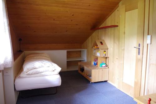 Habitación pequeña con cama y techo de madera. en Ferienwohnung Betula, en Schwarzsee