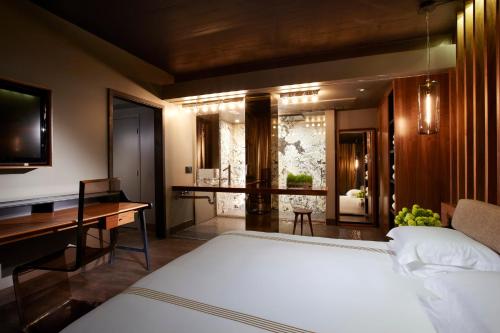 a bedroom with a bed and a desk and a room with a bathroom at The Hollywood Roosevelt in Los Angeles