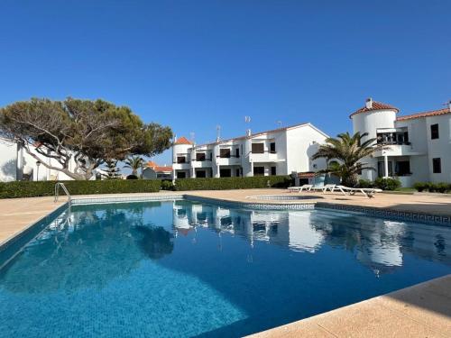 a large blue swimming pool in front of a building at Sa Posta De Sol in Cala en Blanes