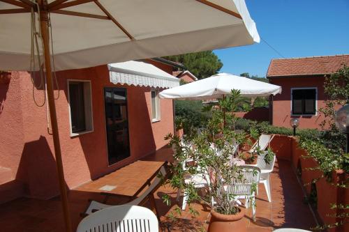 a patio with a table and an umbrella and chairs at Residence Villa Franca in Capoliveri