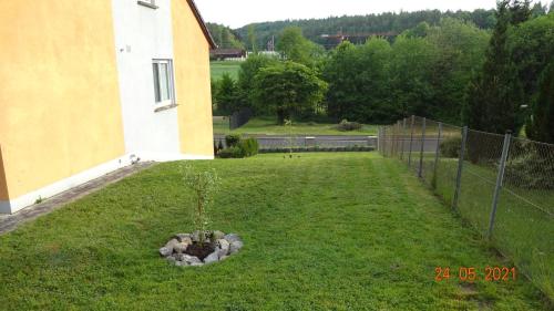 a garden in front of a building with a fence at FeWo Eberau in Ebrach
