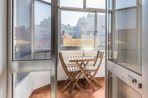 a balcony with a table and two chairs and a window at GuestReady - Breathtaking view at Matosinhos in Matosinhos