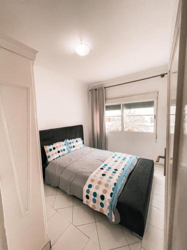 1 dormitorio con cama y ventana en Hôtel champ élysée, en Saidia 