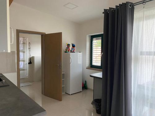 a kitchen with a refrigerator and a window at Penzion Lednice in Lednice