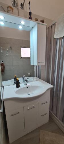 La salle de bains est pourvue d'un lavabo blanc et d'un miroir. dans l'établissement CASA SiSSi, à Augusta
