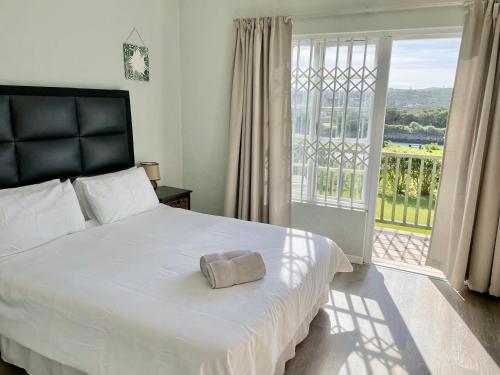 a bedroom with a large bed and a large window at 39 Settler Sands Beachfront Accommodation Sea and River View in Port Alfred