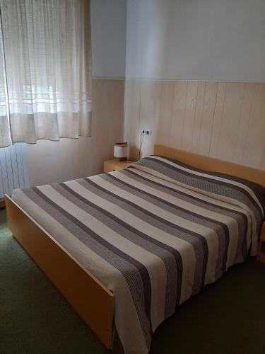 a large bed in a room with a window at Hotel Cucciolo in Donoratico