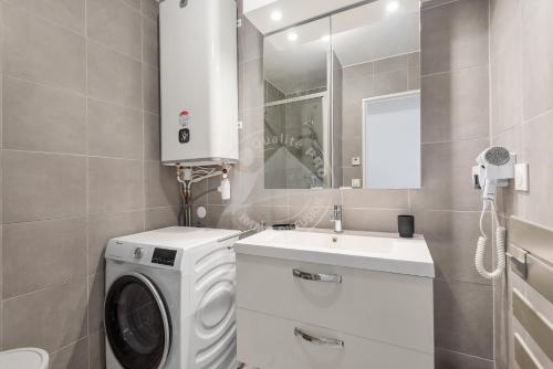 een badkamer met een wasmachine en een wastafel bij AS21932 - Appartement P3 magnifique Vue Mer en dernier étage sur le Front de Mer in Le Grau-du-Roi