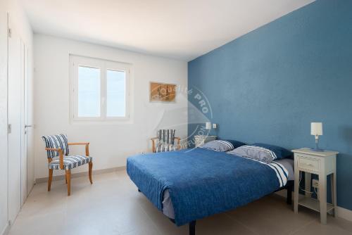 een blauwe slaapkamer met een bed en 2 stoelen bij AS21932 - Appartement P3 magnifique Vue Mer en dernier étage sur le Front de Mer in Le Grau-du-Roi