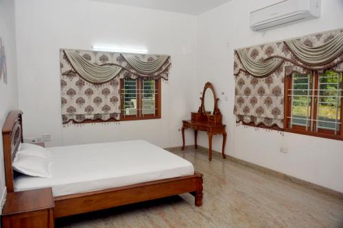 a bedroom with a bed and two windows at Shri Sai Baba Homestay - EB Colony - Trichy in Tiruchchirāppalli