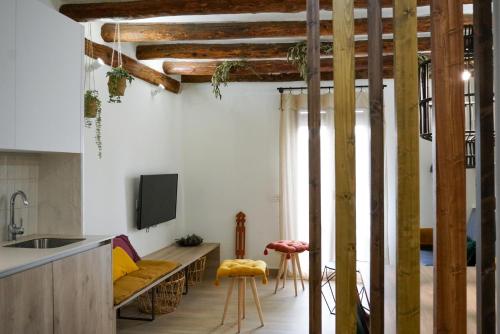 a kitchen with a couch and a tv in a room at Apartaments la Rambla - Arbequina - 6 persones in Cornudella