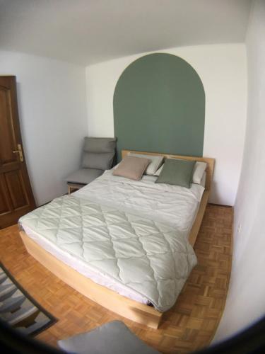 a bedroom with a large bed with a green headboard at Road View Apartment Celeia in Celje