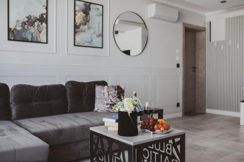 a living room with a couch and a table with a mirror at Apartamenty BLUE BALTIC SPA Jacuzzi & Sauna MORZE in Chłopy